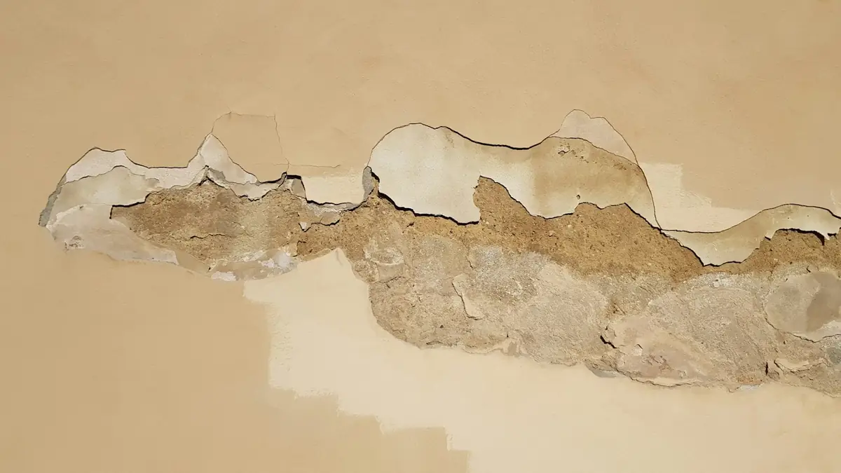 Plaster peeling off a wall after water got in behind it - Basement Leak Detection in Revere