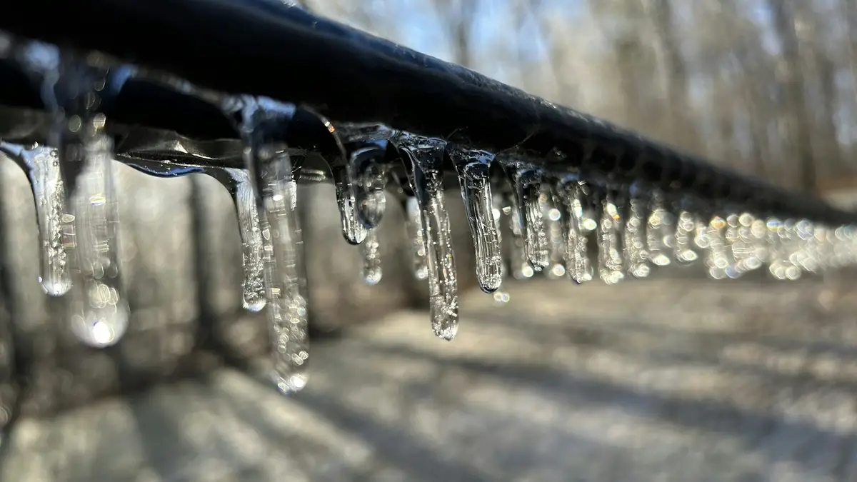 Icicles hanging from an outdoor pipe in winter